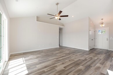 Unfurnished room with ceiling fan, light wood-style flooring, and high vaulted ceiling