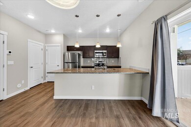 Kitchen with dark brown cabinets, decorative backsplash, a peninsula, dark wood-style floors, and a textured ceiling