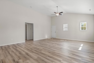 Unfurnished living room featuring high vaulted cei