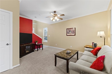 Living area featuring crown molding, light carpet, and ceiling fan