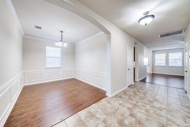 Tiled spare room with a chandelier, crown molding