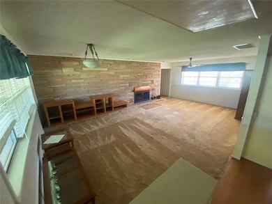 Unfurnished living room with a stone fireplace and carpet flooring