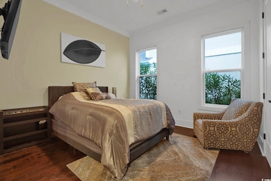 Bedroom with wood-type flooring and crown molding