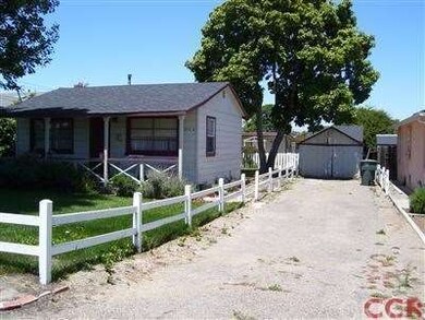 Side driveway with older garage and second unit in
