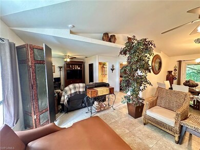 Living room featuring lofted ceiling, light tile p