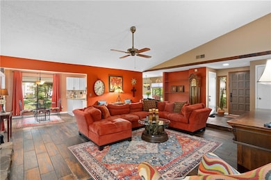 Living area with lofted ceiling, ceiling fan, and dark wood finished floors
