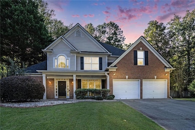 Traditional-style home with covered porch, brick siding, and a front yard