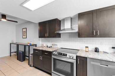Kitchen with backsplash, wall chimney exhaust hood
