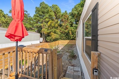 Fenced backyard featuring view of wooded area and a deck
