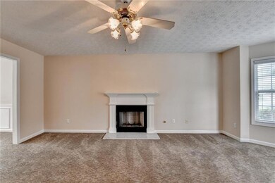 Unfurnished living room featuring carpet, a firepl