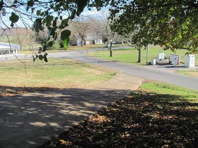 This charming Southern home's curb appeal is complemented with the wide concrete driveway, a concrete parking area and two car attached carport. 