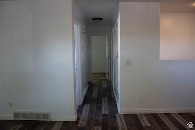 Corridor featuring dark wood-type flooring