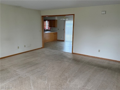 Empty room feaLiving room look across and into the kitchen