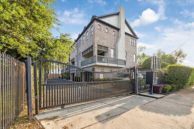 Modern, multi-story brick townhouse with a gated e