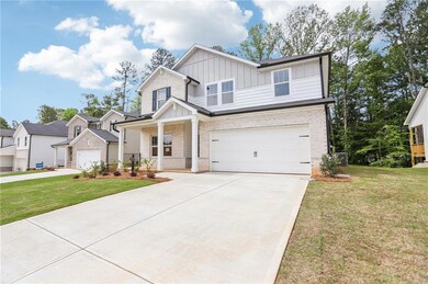 Craftsman-style home with board and batten siding, brick siding, concrete driveway, a garage, and a front lawn