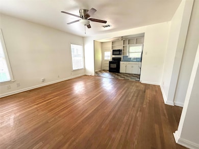 Unfurnished living room with a ceiling fan, dark 