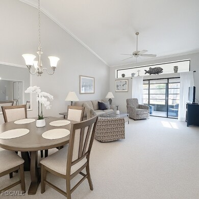Carpeted dining space with ornamental molding and a chandelier