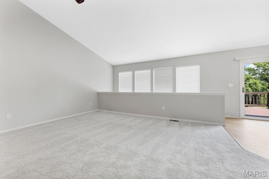 Spare room with lofted ceiling and light carpet