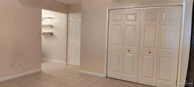 Unfurnished bedroom with light tile patterned flooring, baseboards, and a closet