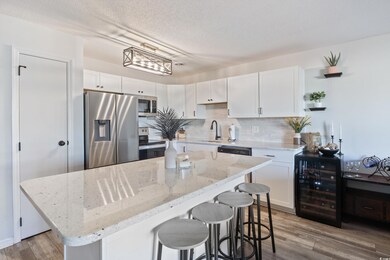 Kitchen with white cabinets, light hardwood / wood
