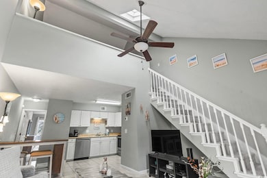 Tiled living room with ceiling fan, lofted ceiling