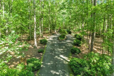 Paved drive has numerous brick columns with outdoor lighting on mechanical timers, and a decorative landscaped and brick surround island in the center