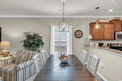 Dining area with ornamental molding and recessed lighting