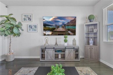 Living area featuring baseboards, healthy amount of natural light, and wood finished floors