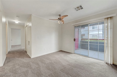 Spare room with carpet floors, a ceiling fan, orna