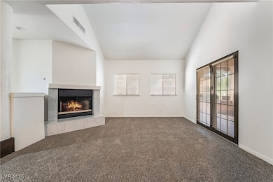 Unfurnished living room featuring vaulted ceiling,