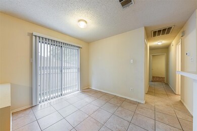 Unfurnished room featuring a textured ceiling, li