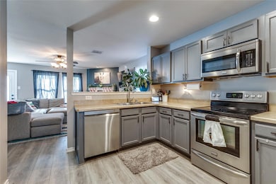Kitchen with ceiling fan, sink, gray cabinets, app