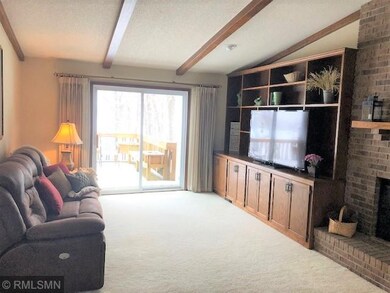 Living room with built ins and patio door to deck.