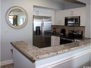Kitchen featuring stainless steel appliances, tasteful backsplash, light stone countertops, white cabinetry, and baseboards