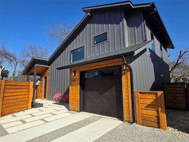 View of front of home featuring board and batten siding, roof with shingles, fence, and an attached garage