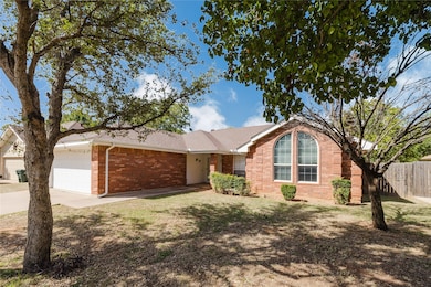 Ranch-style home featuring brick siding, concrete driveway, an attached garage, and roof with shingles
