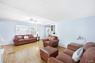Living room with ceiling fan, built in features, a