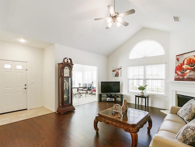 Living area with visible vents, a fireplace, wood 