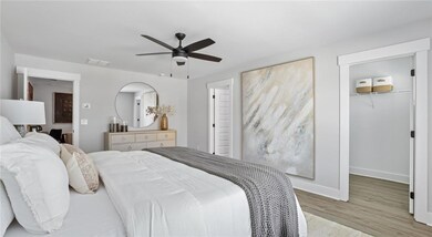 Bedroom with a spacious closet, wood finished floo