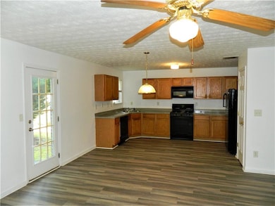 Kitchen with black appliances, brown cabinets, hea