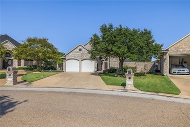 Obstructed view of property with a front yard, driveway, an attached garage, and brick siding