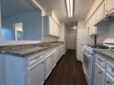 Kitchen with white gas range oven, dishwashing ma