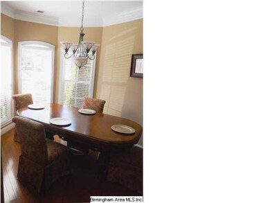 DINING ROOM WITH TRIPLE BAY WINDOWS AND HARDWOOD F