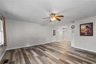 Empty room featuring visible vents, baseboards, wo