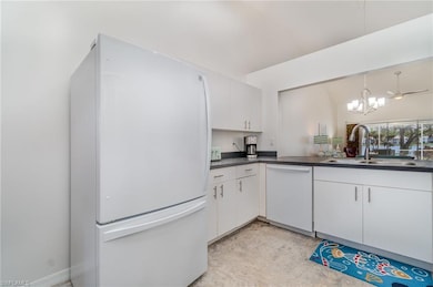 Kitchen with white appliances, sink, and white cab