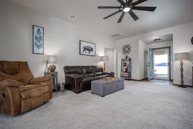 Carpeted living room with ceiling fan