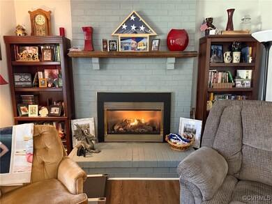 Living area featuring a brick fireplace and wood f