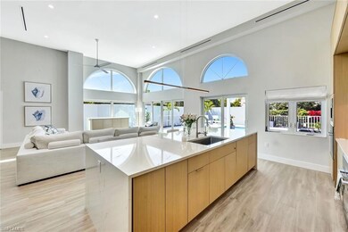 Kitchen with modern cabinets, a sink, open floor plan, light wood-style floors, and a large island with sink