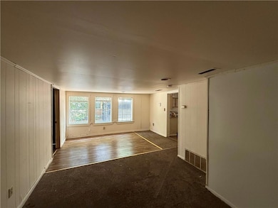 Empty room with carpet flooring and wood finished floors