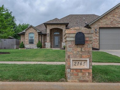 French country home with brick siding, a shingled roof, and an attached garage